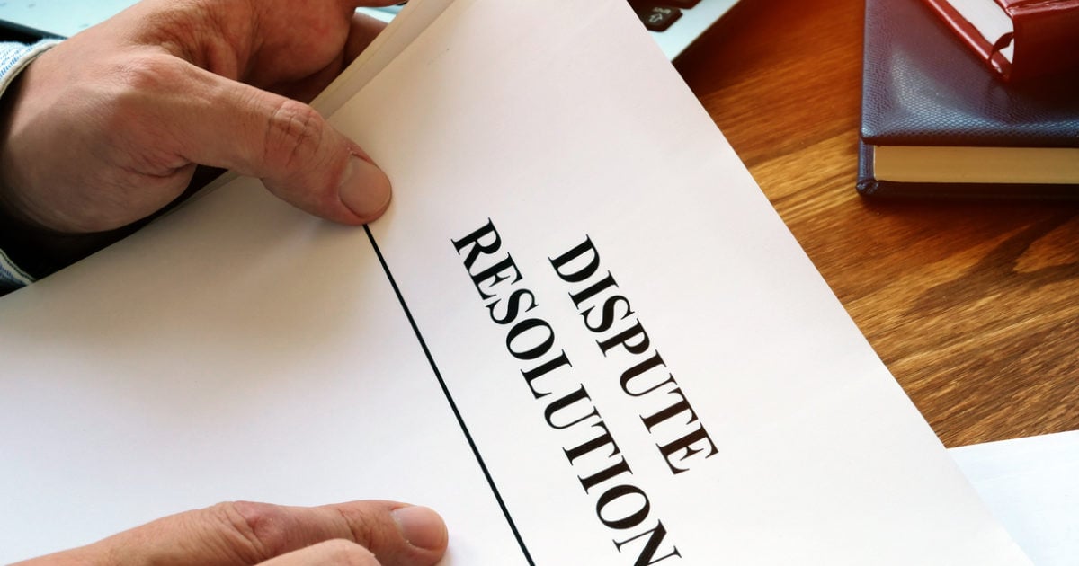 Hands holding a printed document headed Dispute Resolution