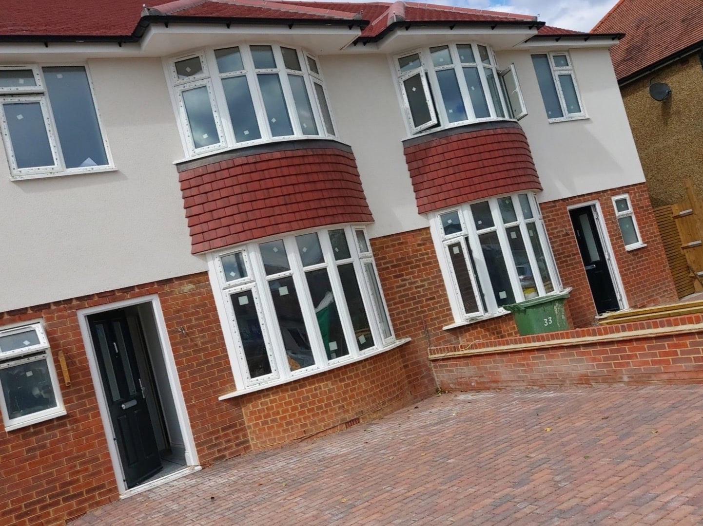 Pair of white rendered semi-detached houses with red tile-hung bays