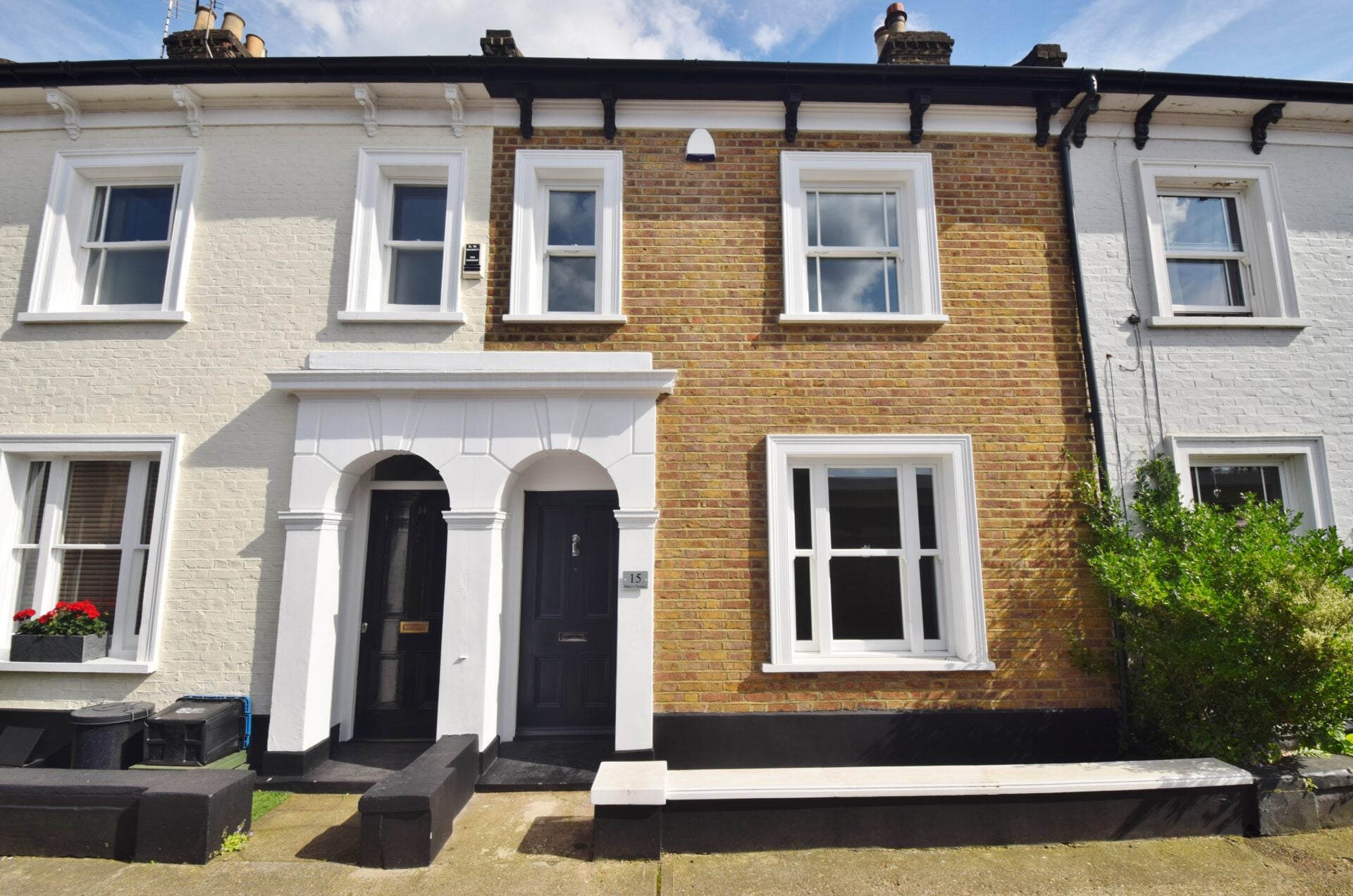 Victorian terrace in white-painted and yellow brick with twin arched doorways