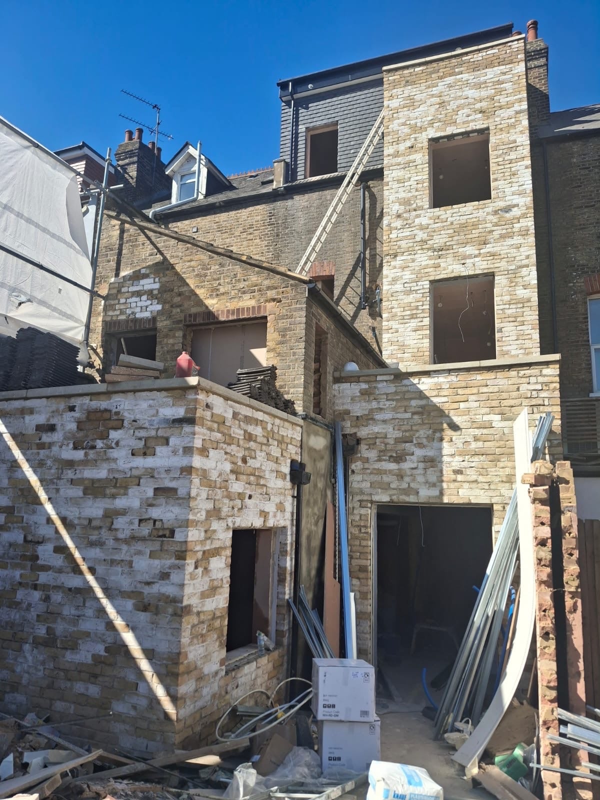 Rear of a brick terrace with a new brick extension under construction