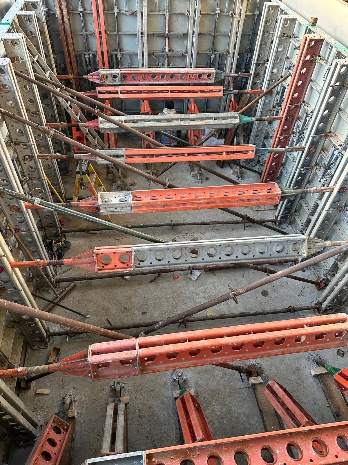 Steel formwork and orange props seen from above
